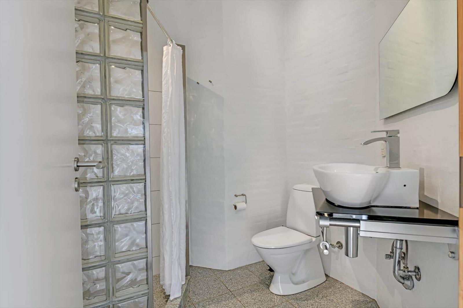 Badezimmer mit Dusche, Toilette und Waschbecken.