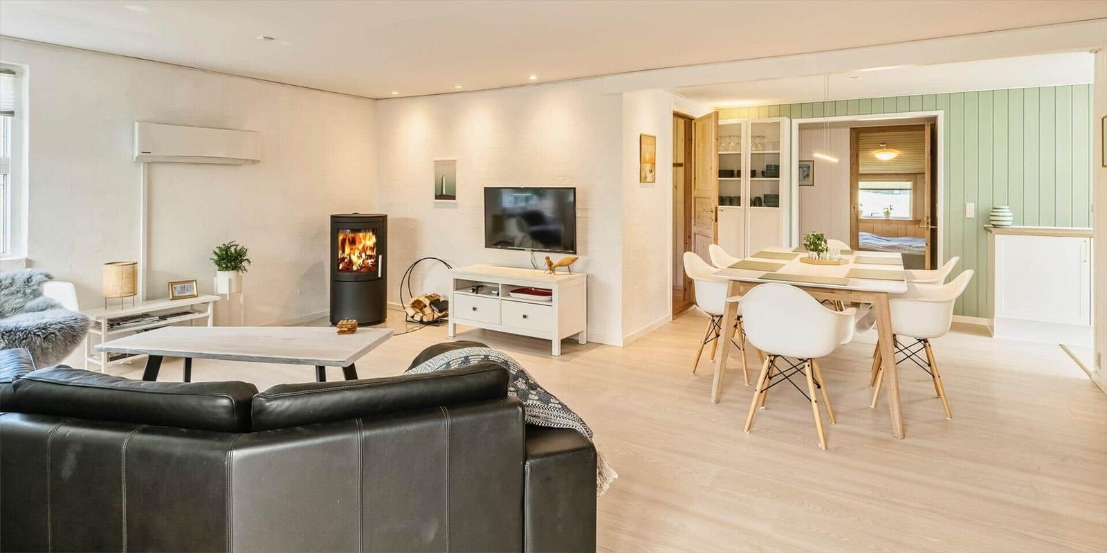 Wohn- und Essbereich mit Kamin, TV und Esstisch mit Stühlen.