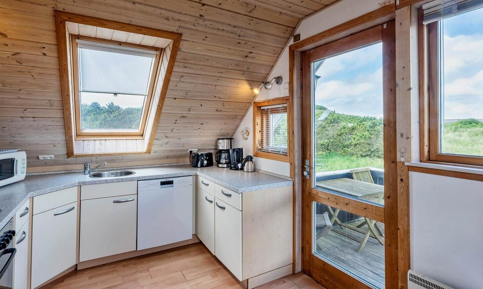 Küche mit Spüle, Waschmaschine und Fenster zum Balkon