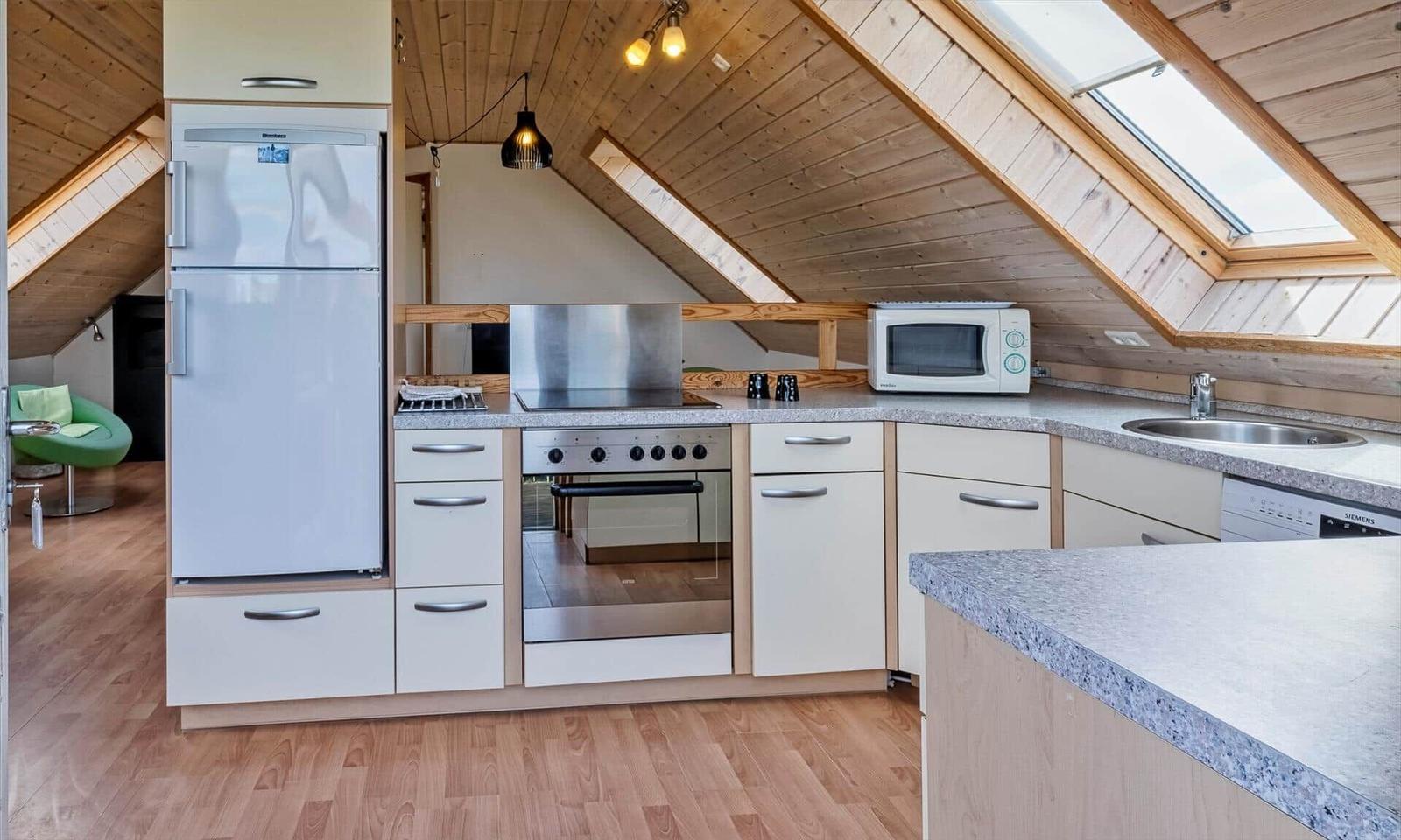 Küche mit Kühlschrank, Herd und Dunstabzug.
