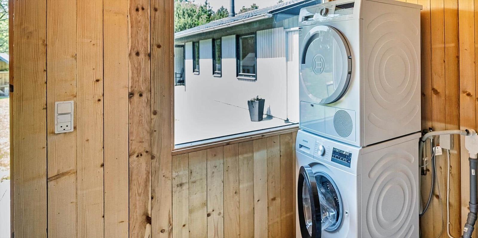 Wäschetrockner und Waschmaschine in Holzhaus, Blick auf Außenbereich