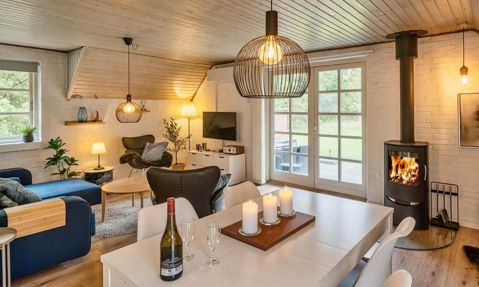 Ein Raum mit Esstisch, Kamin und Wohnbereich mit Sofa und Fernseher.