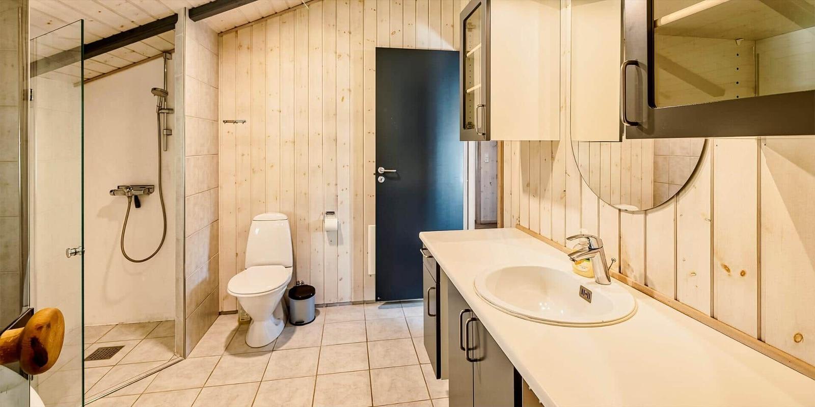 Badezimmer mit Dusche, Toilette und Waschbecken.