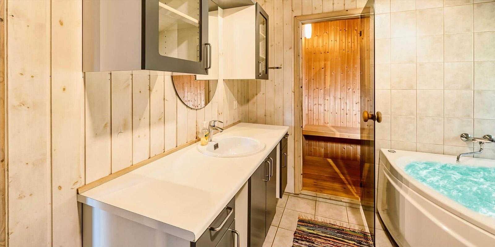 Badezimmer mit Dusche, Whirlpool und Holzwand