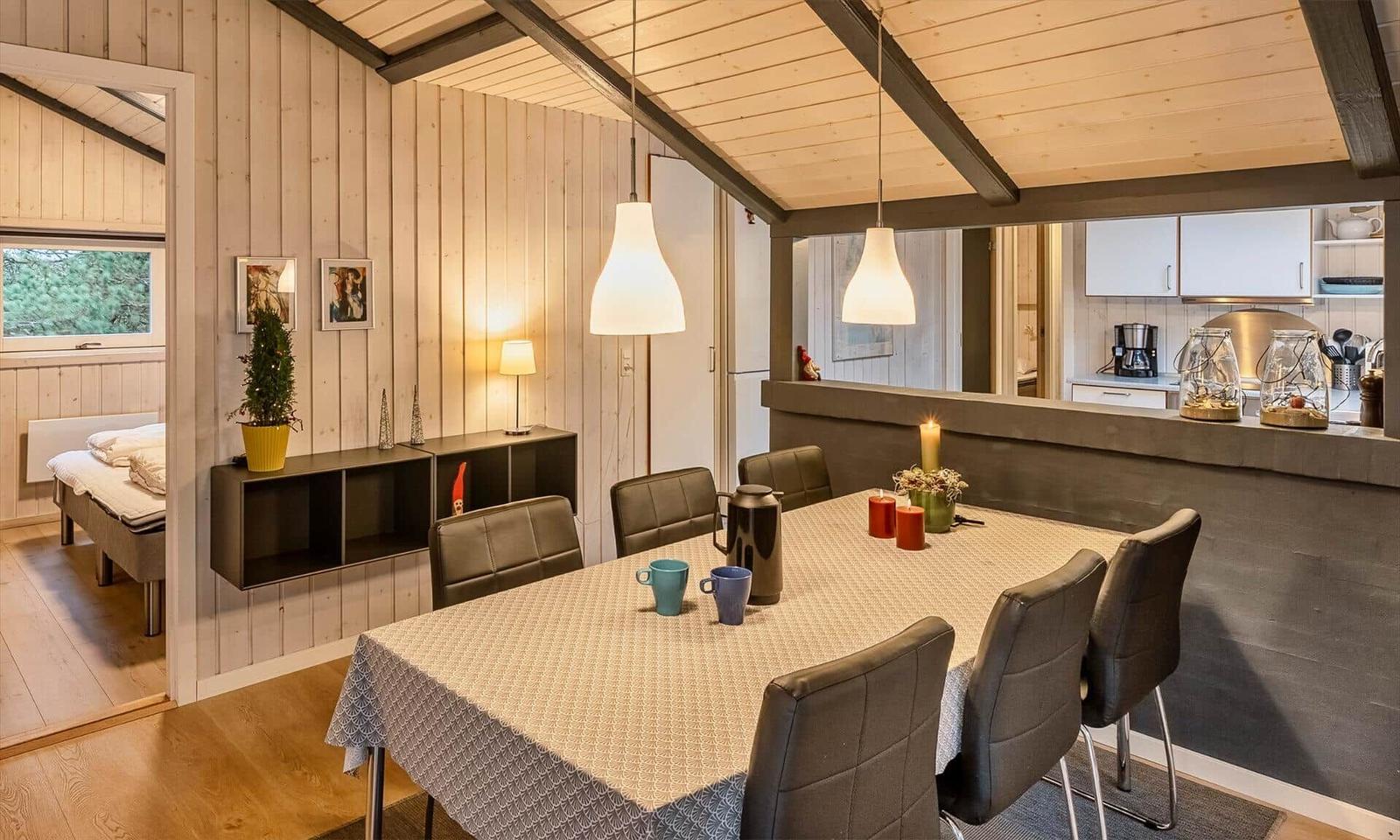 Esszimmer mit Tisch, Stühlen und Blick in Küche und Schlafzimmer.