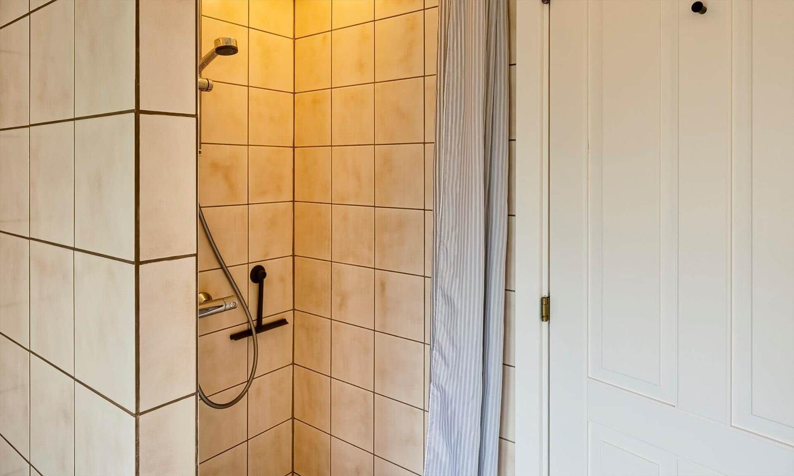 Dusche mit Fliesen und Duschvorhang