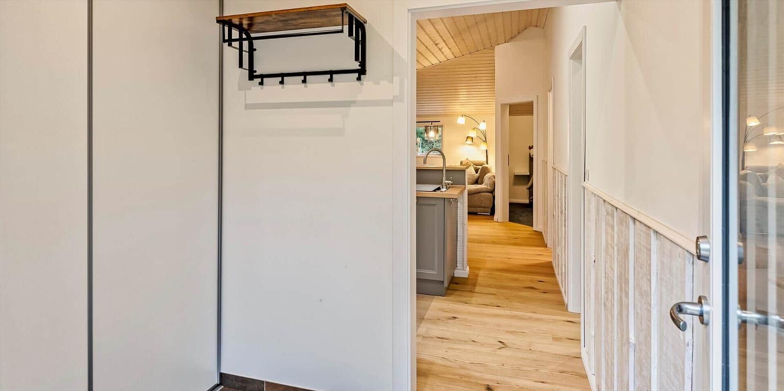 Hallenflur mit Holzboden und Blick in Küche und Wohnzimmer