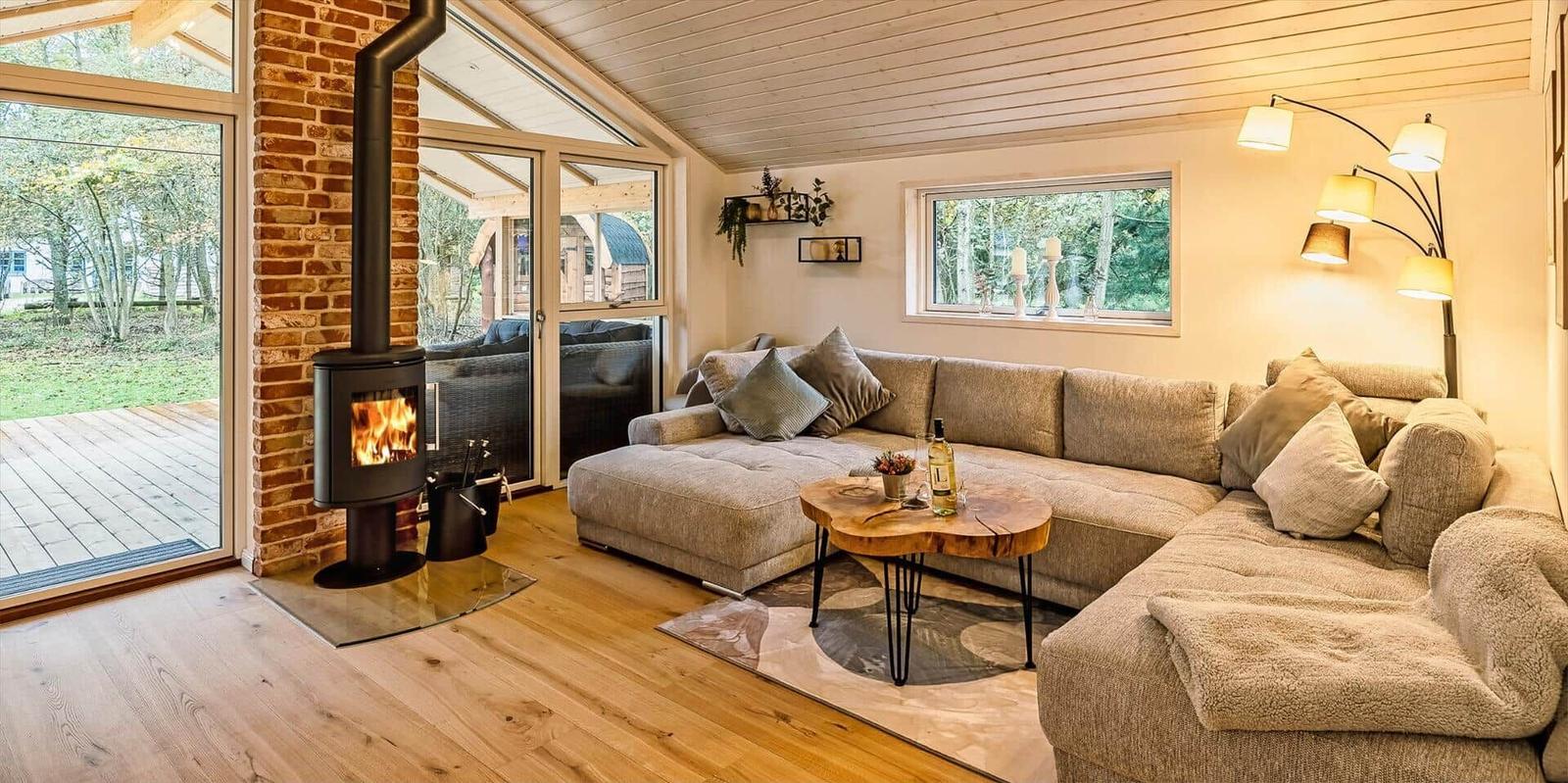 Wohnzimmer mit Sofa, Kamin und Terrassentür