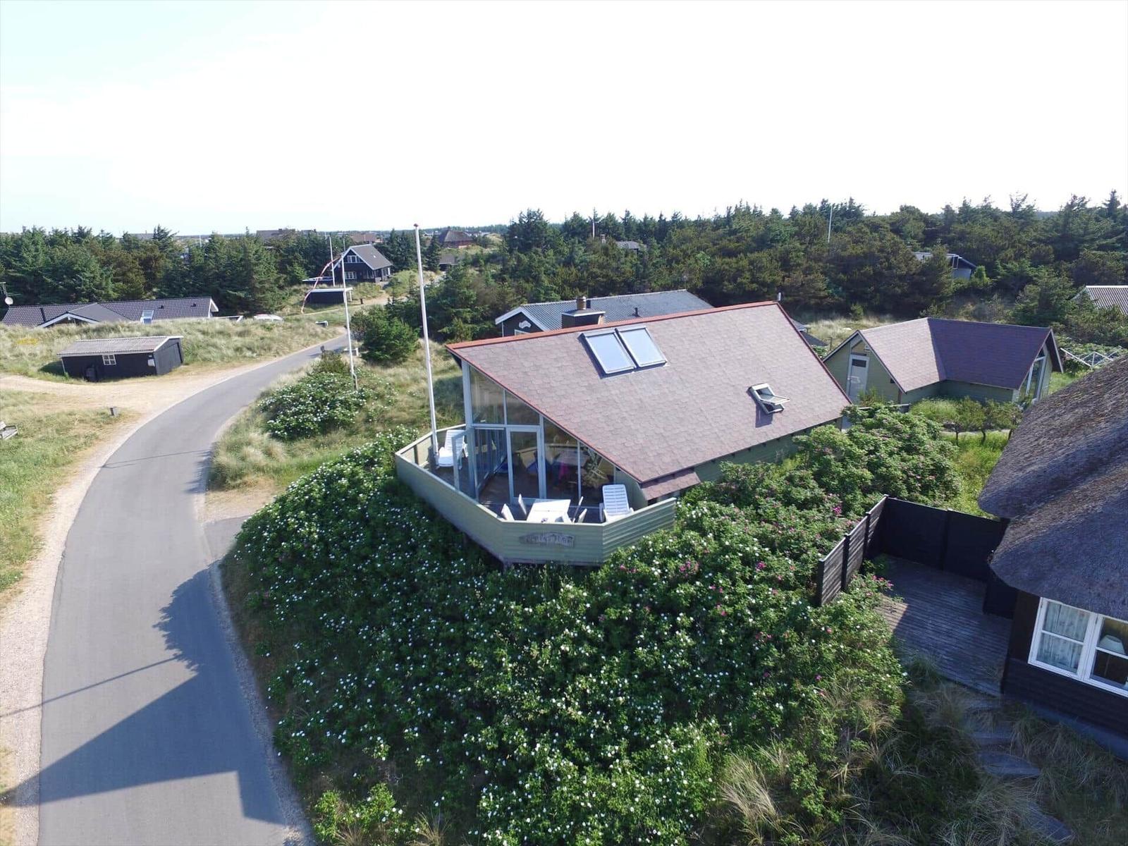 Moderne Villa mit Dachterrasse und Garten. Umgeben von Grünflächen und Bäumen.