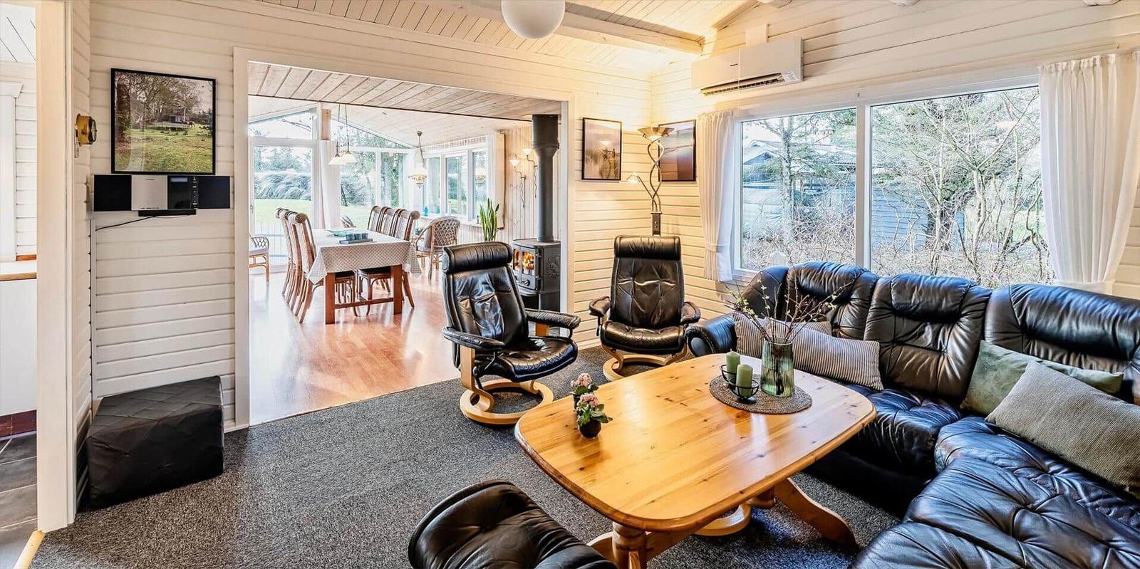 Wohnzimmer mit Ledersofa, Holztisch und Blick in Essbereich
