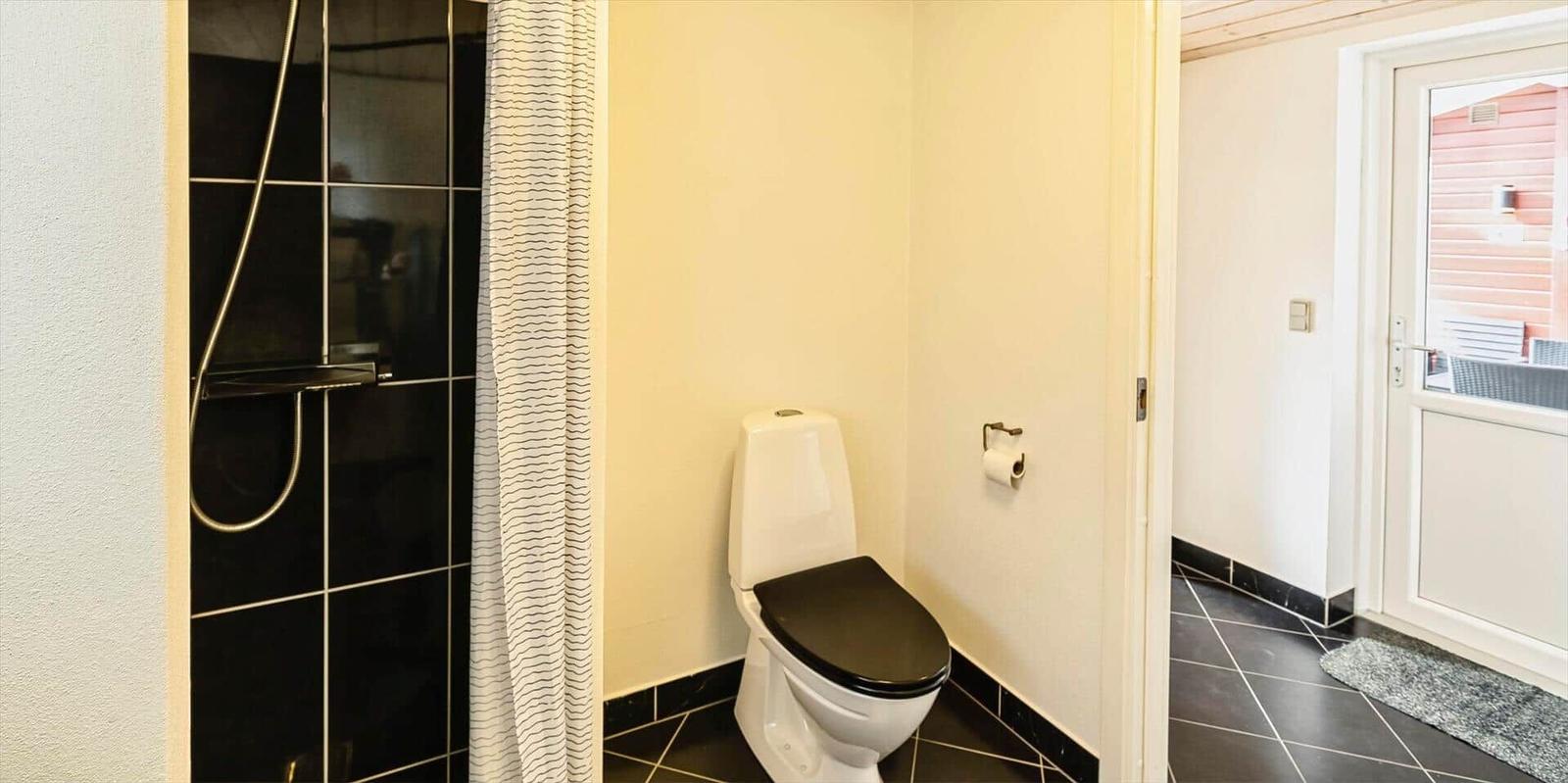 Bad mit Dusche, Toilette und Tür zum Flur