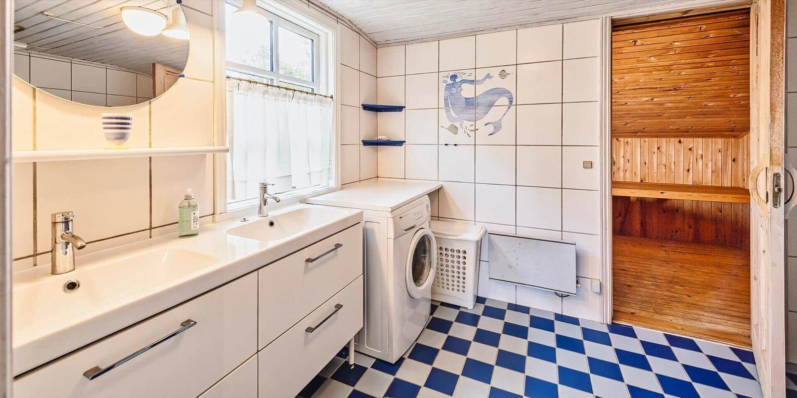 Badezimmer mit Waschmaschine, Spiegel und Sauna