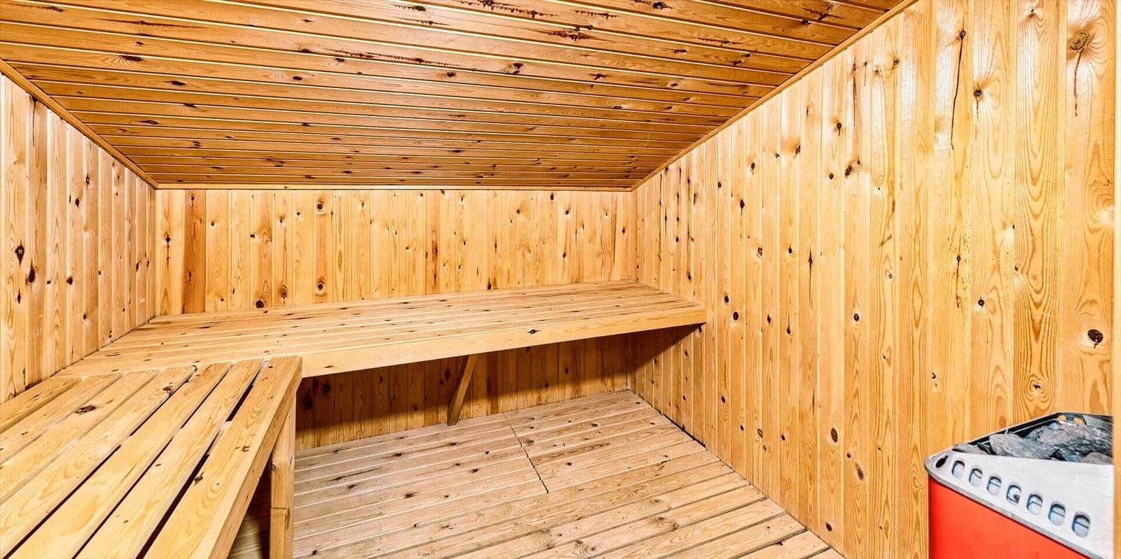 Holzsauna mit Sitzbank und Heizung.