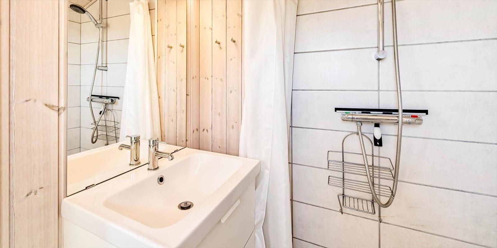 Bad mit Dusche, Waschbecken und Spiegel