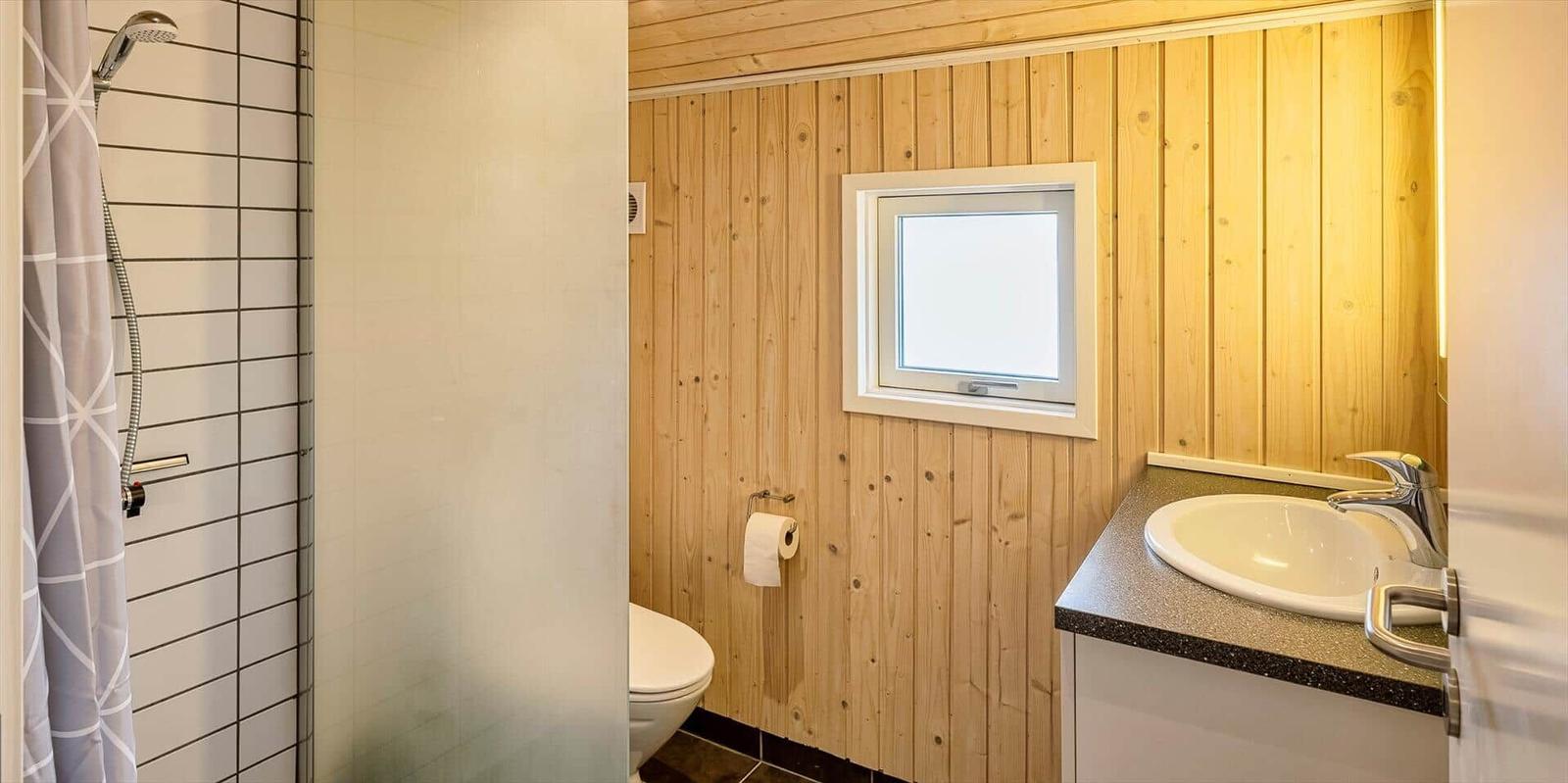 Badezimmer mit Dusche, WC und Waschbecken mit Spiegel