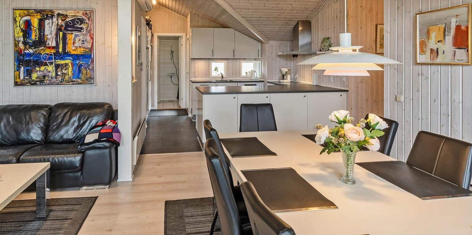 Wohn- und Essbereich mit Küche und Schlafzimmer im Hintergrund.