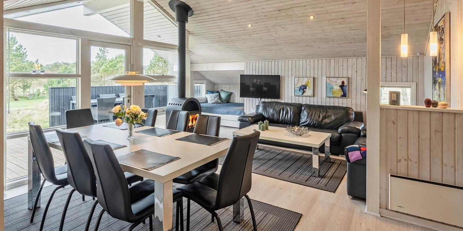 Essbereich mit Tisch und Stühlen, Wohnzimmer mit Sofa und Kamin.