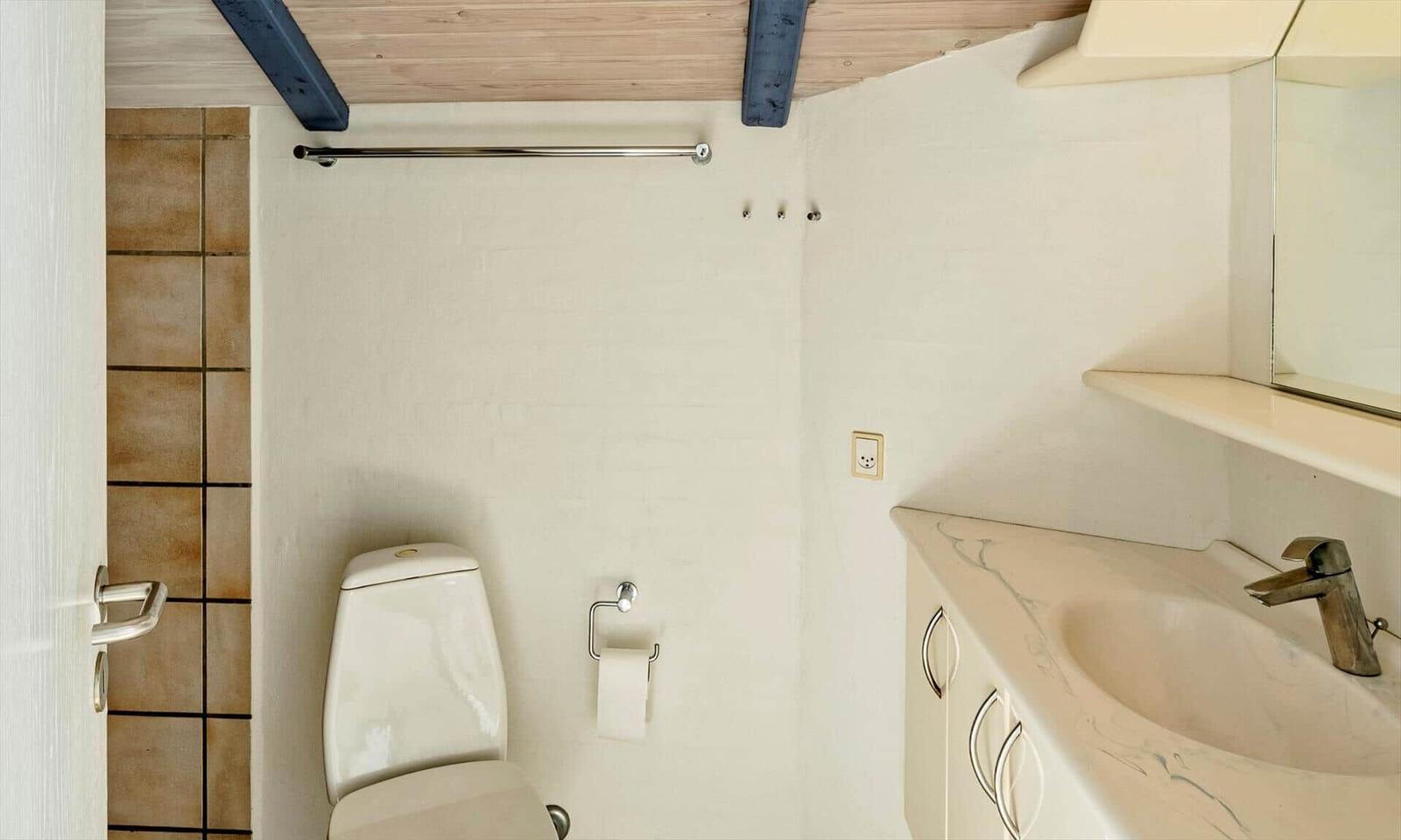 Badezimmer mit Toilette, Waschbecken und Spiegel