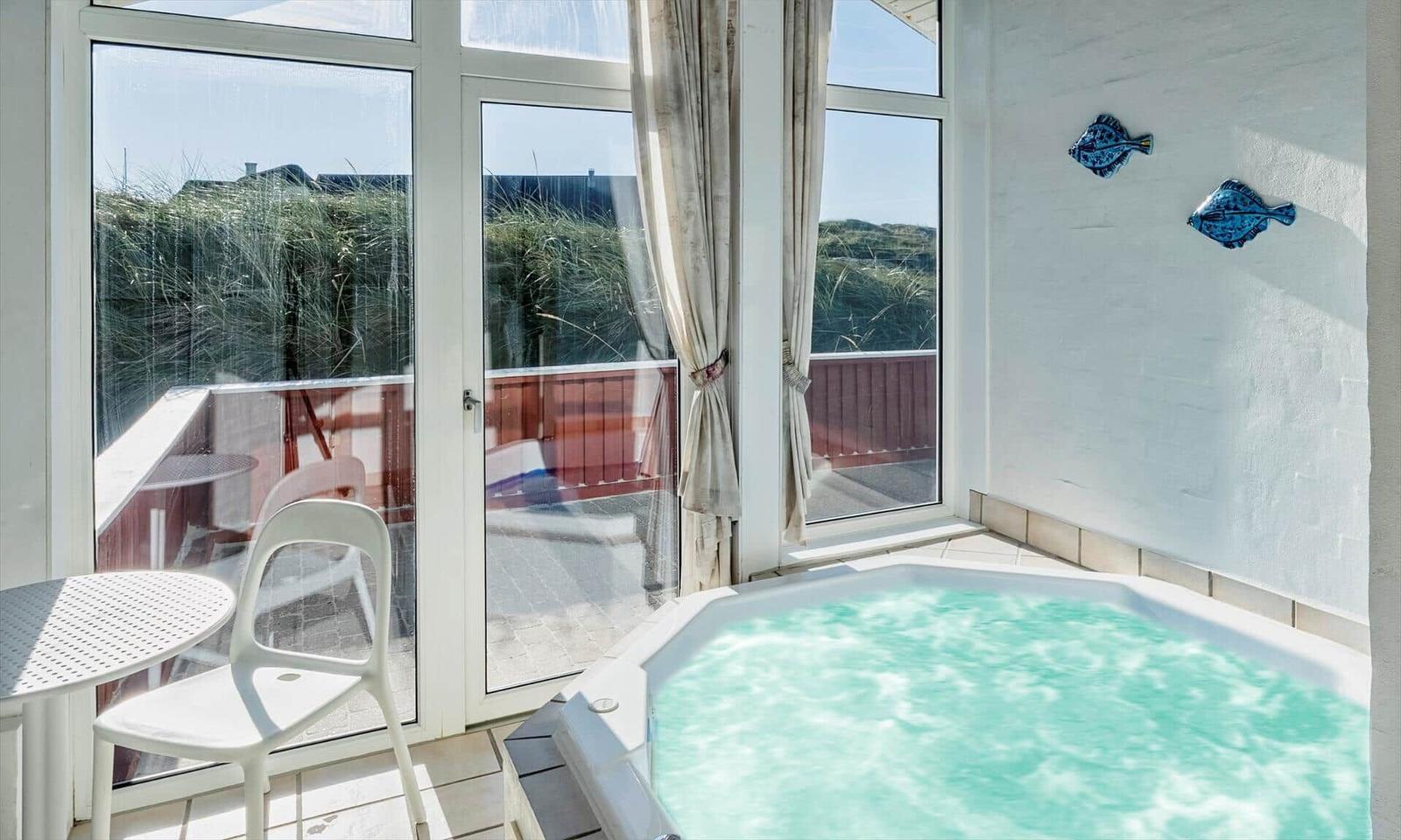 Innenhof mit Whirlpool, Terrasse und Blick auf Dünen.