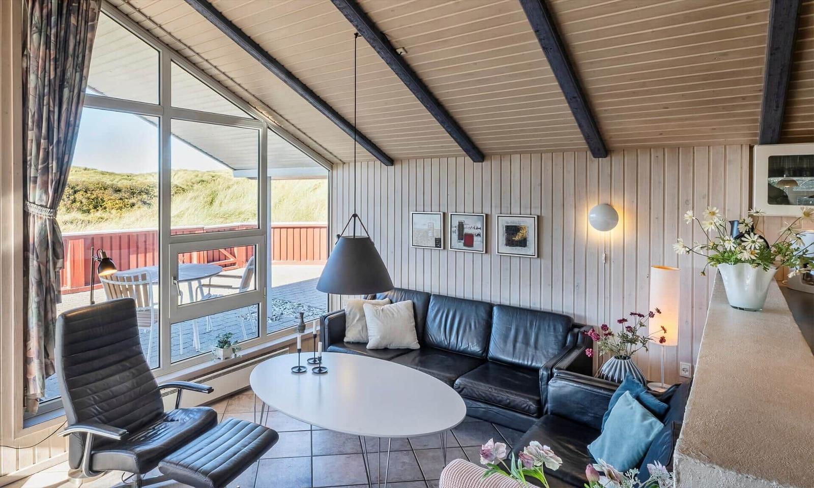 Wohnzimmer mit Sofa, Tisch und Blick auf Balkon