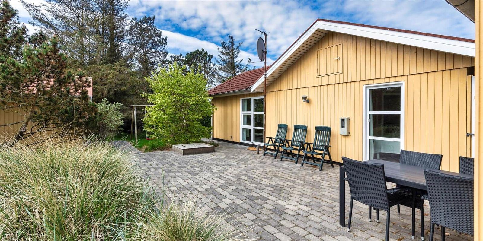 Helle Holzhaus mit Terrasse, Gartenmöbel und Grillplatz. Hinterhof mit Spielplatz.