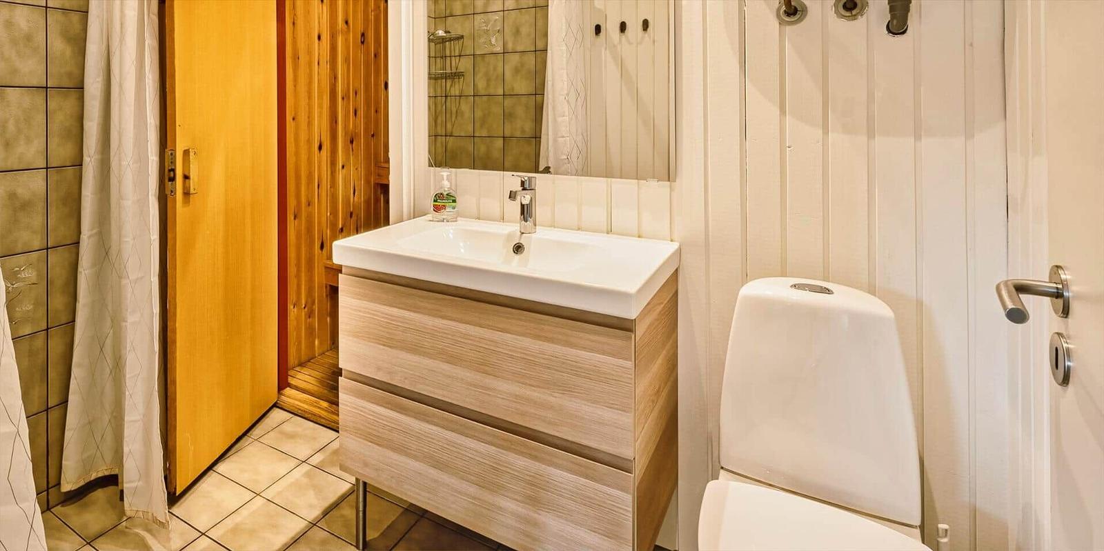 Badezimmer mit Waschbecken, Toilette und Dusche.