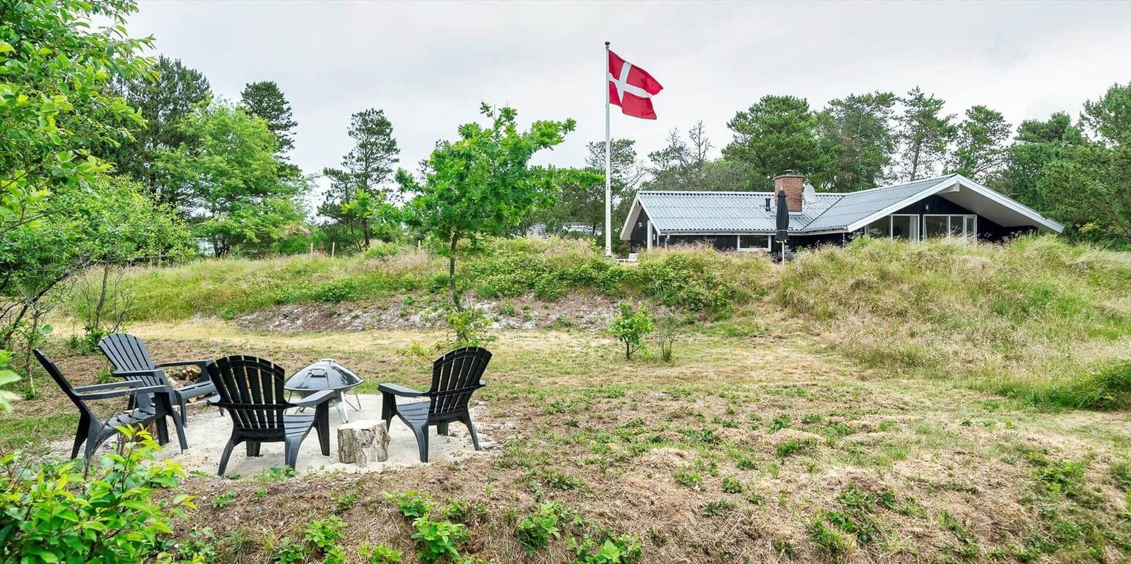 Haus mit Grillplatz und dänischer Flagge im Grünen