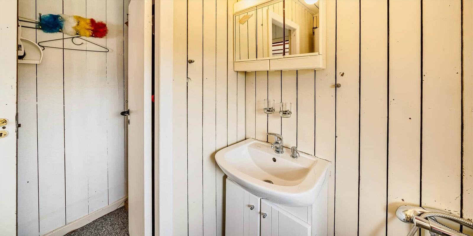 Badezimmer mit Waschbecken, Spiegel und Dusche.