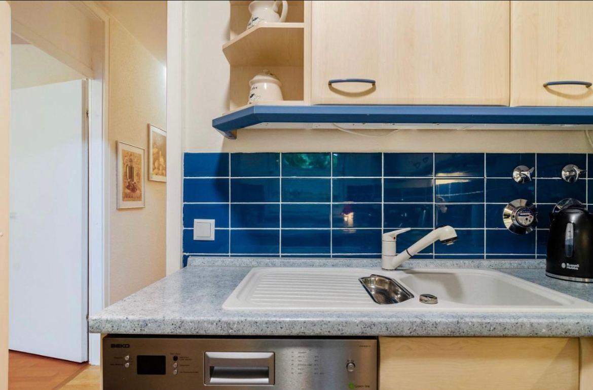 Küche mit blauer Fliesenspiegelwand, Spüle und Küchenspüle