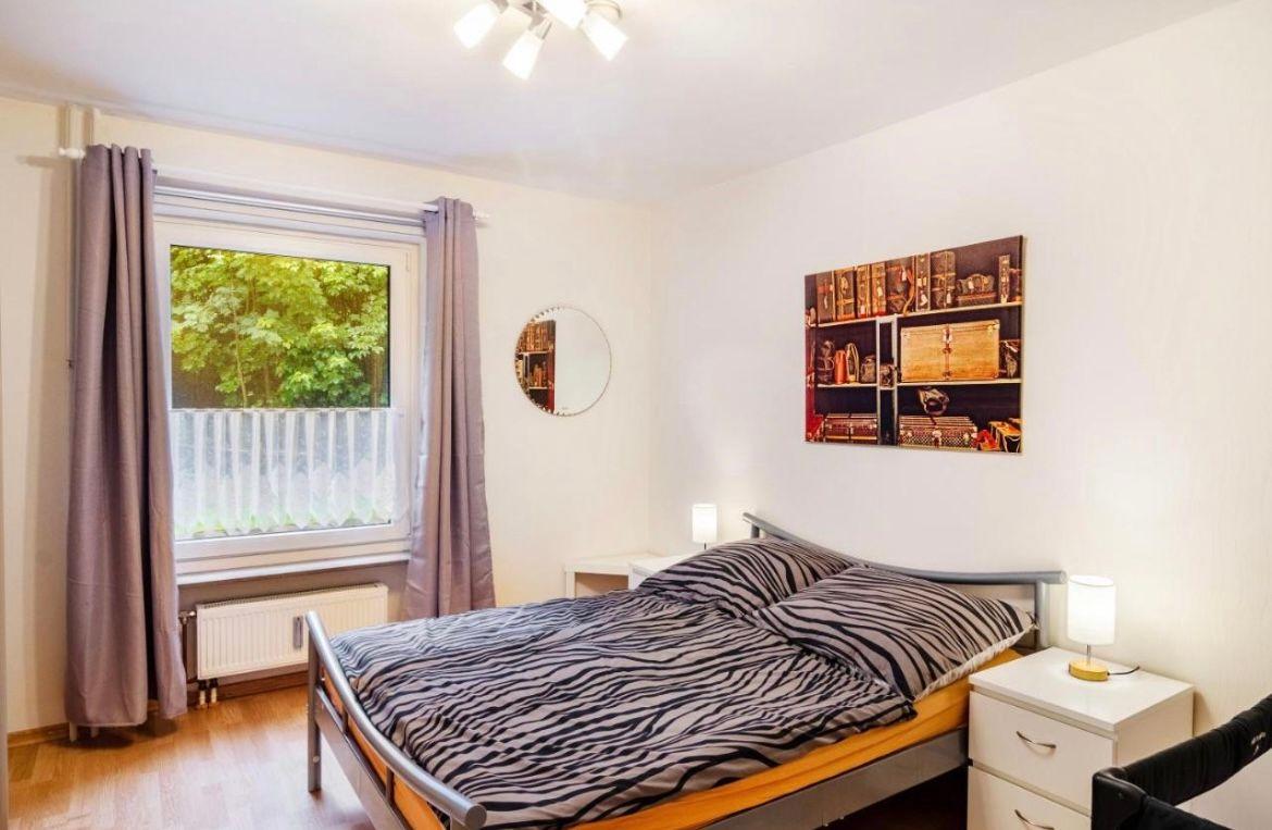 Schlafzimmer mit Bett, Fenster und Wandbild.