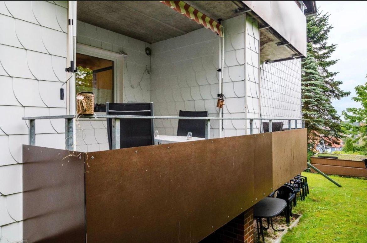 Terrasse mit Tisch, Stühlen und Sicht auf Grünfläche