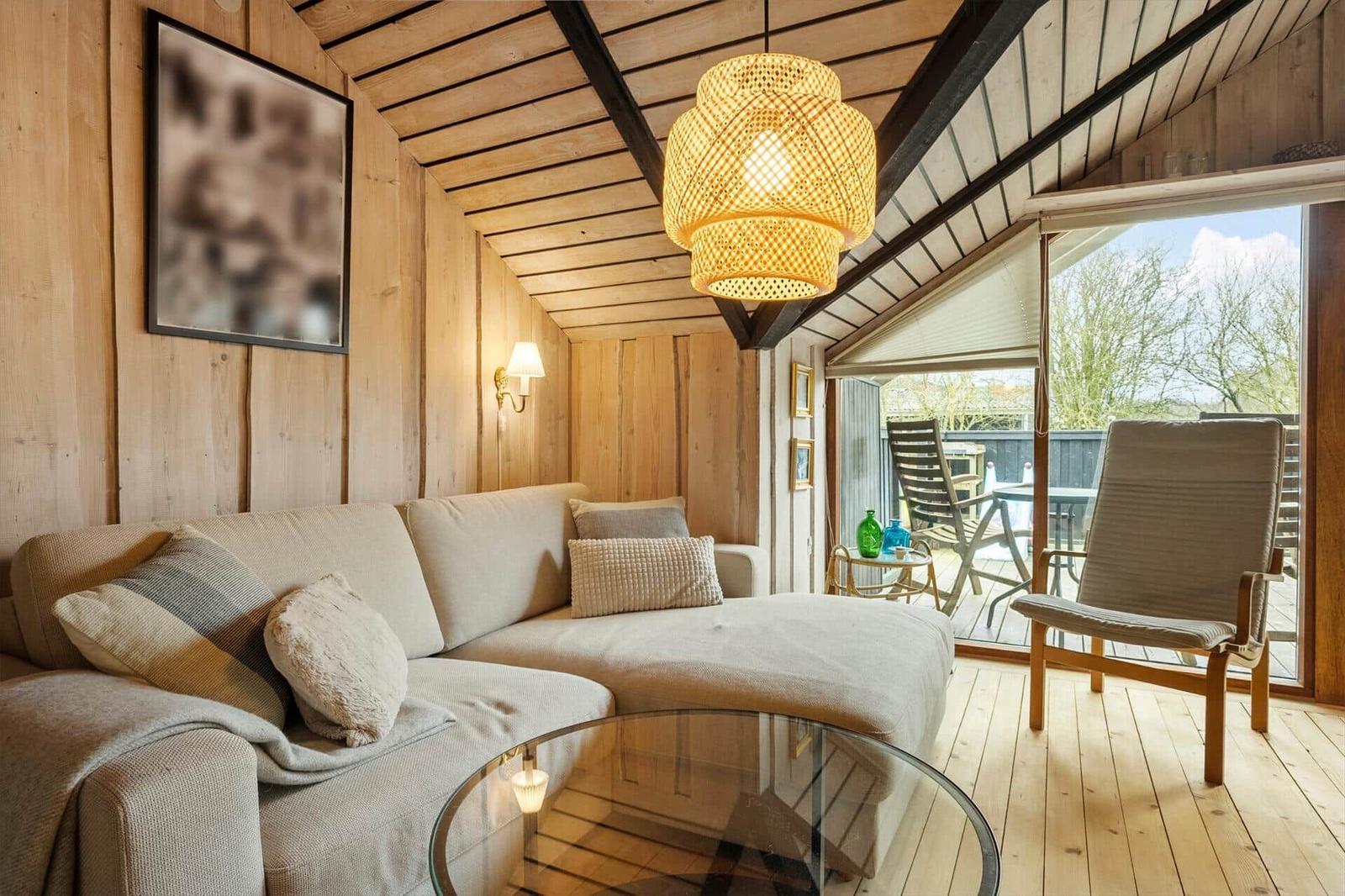 Wohnzimmer mit Sofa, Glas-Tisch und Blick auf Terrasse