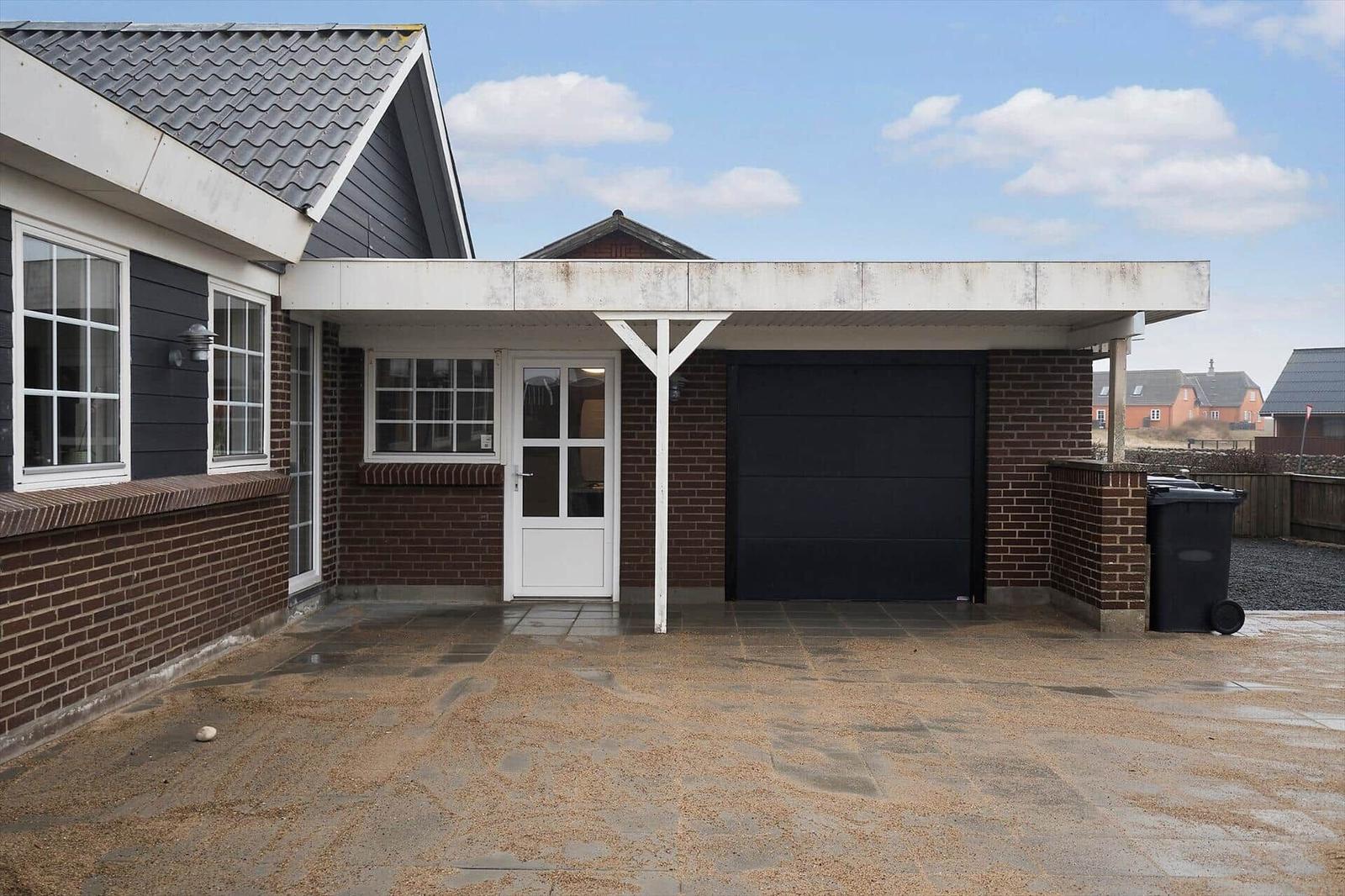 Haus mit Garagenbereich und Eingangstür unter Vordach.