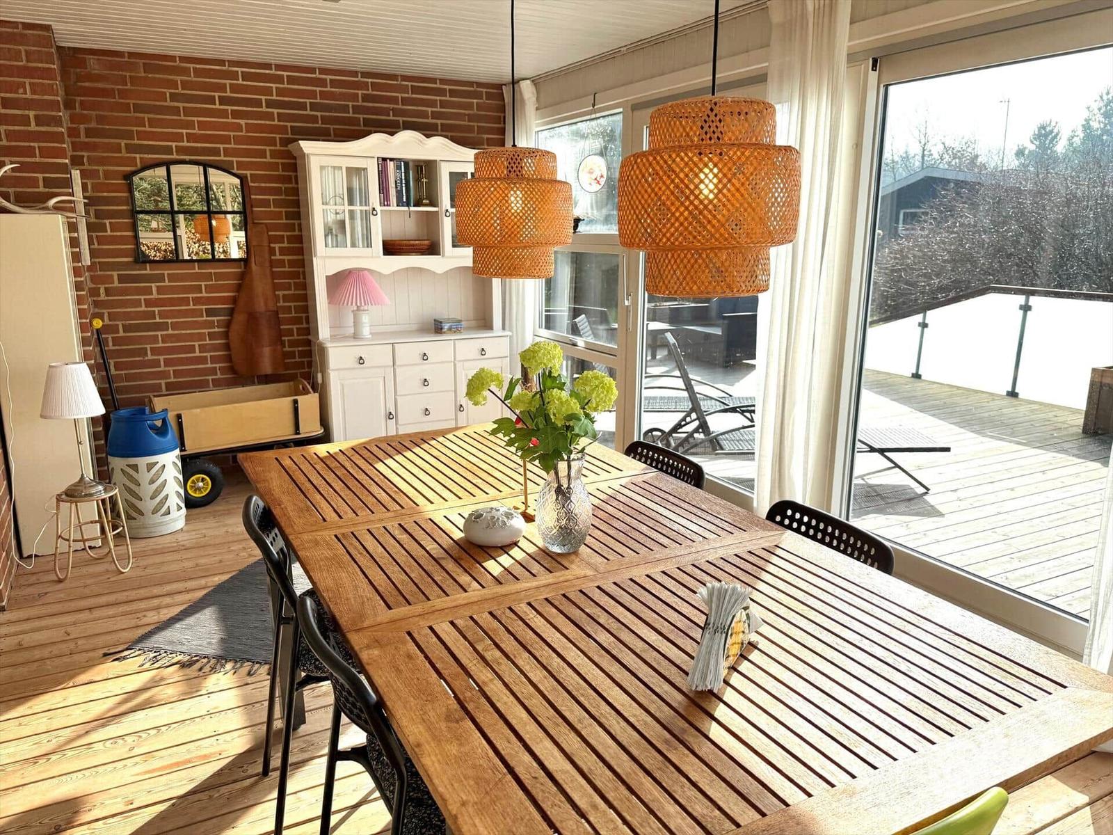 Esszimmer mit Holztisch, Hängelampen und Blick auf Balkon