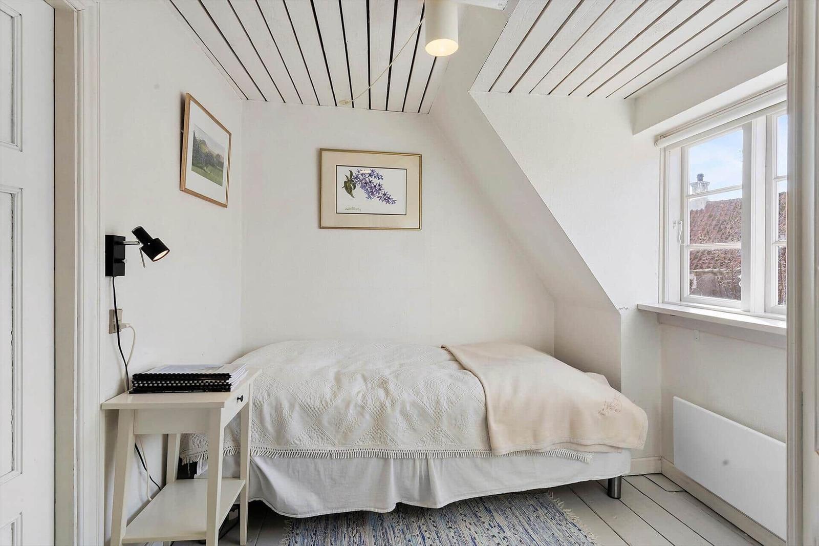 Bedroom with sloped ceiling, window, and bed