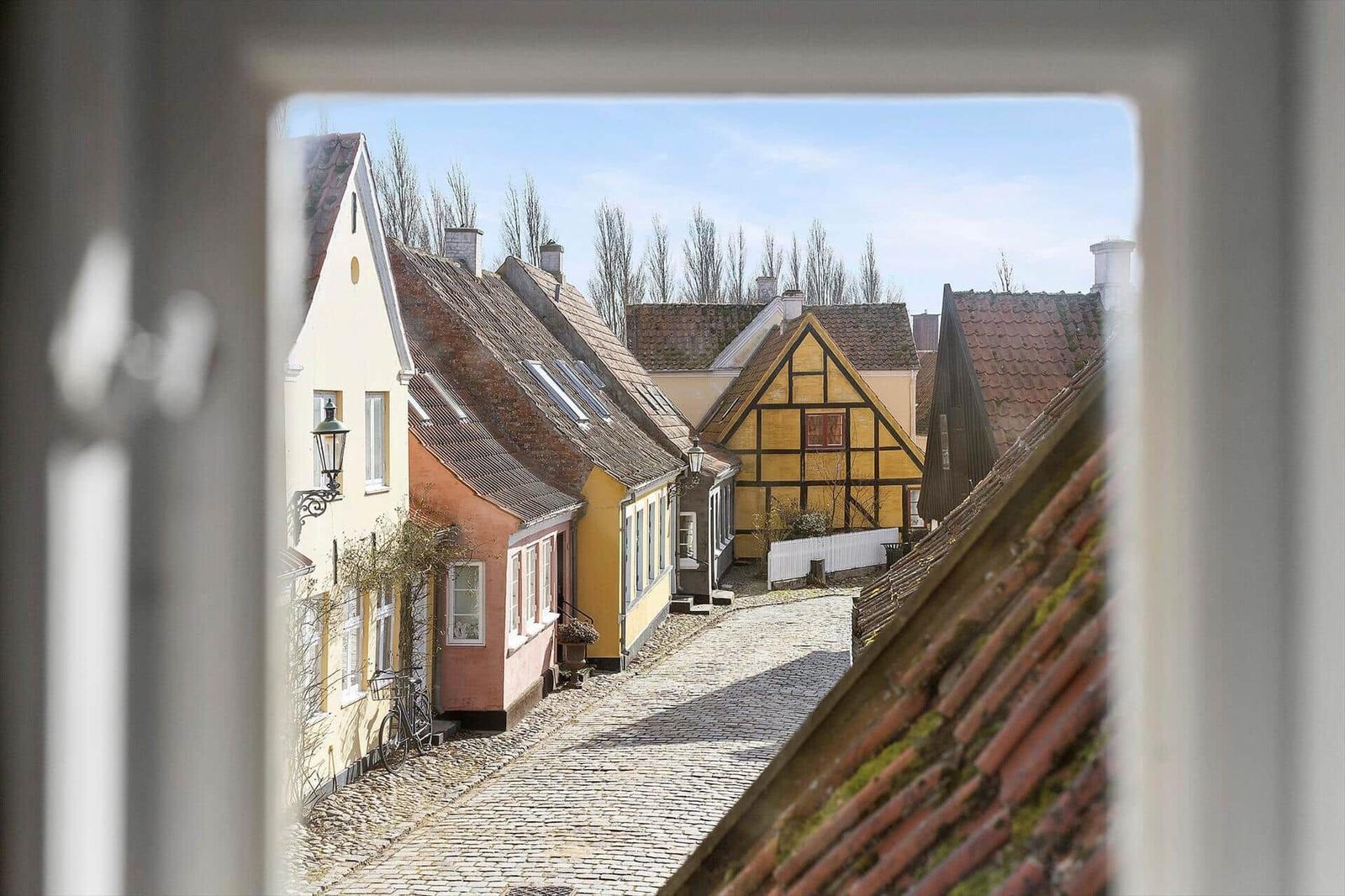 View through window onto street with traditional houses and cobblestone
