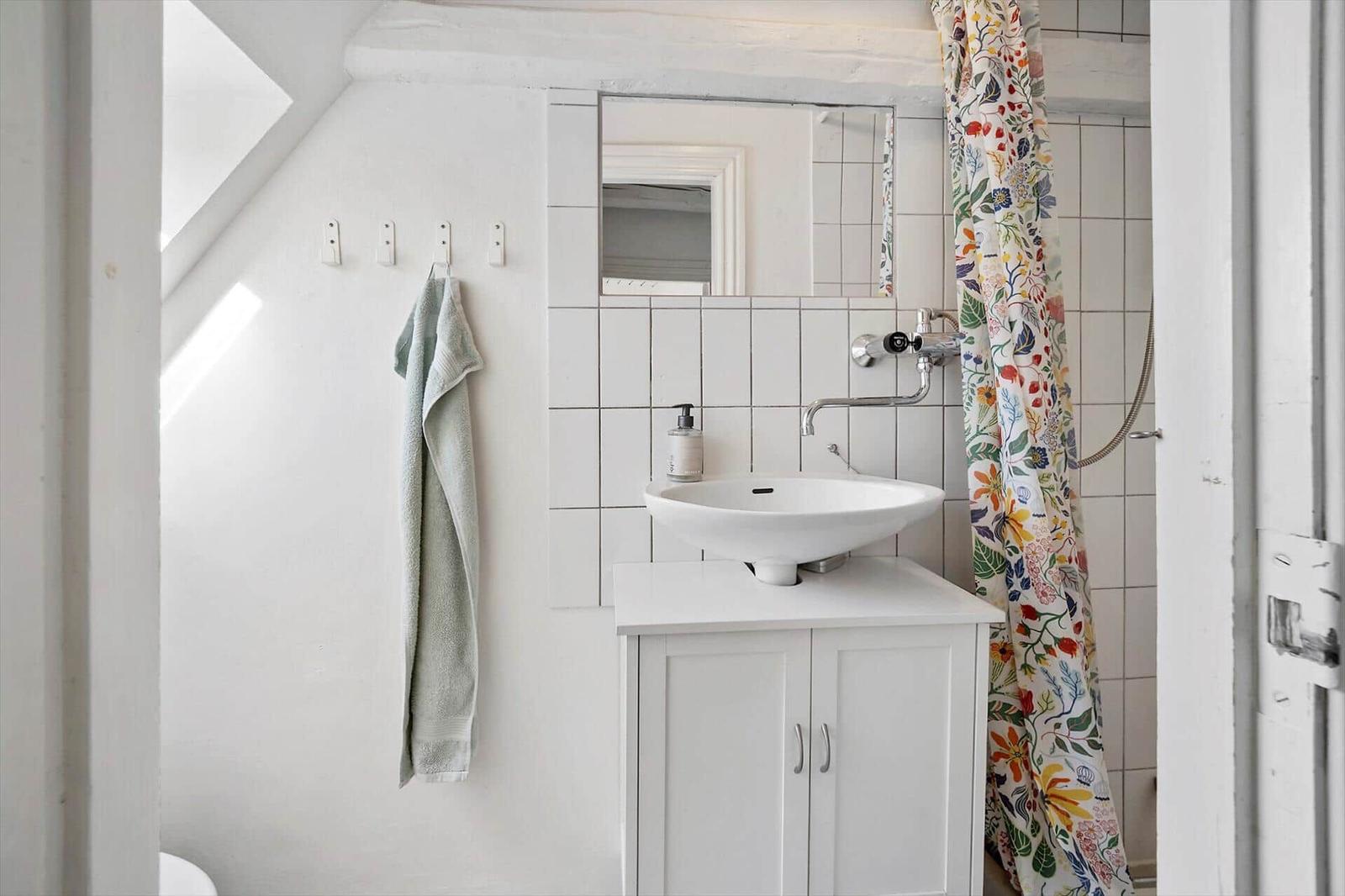 Bathroom with sink, mirror, and shower curtain.