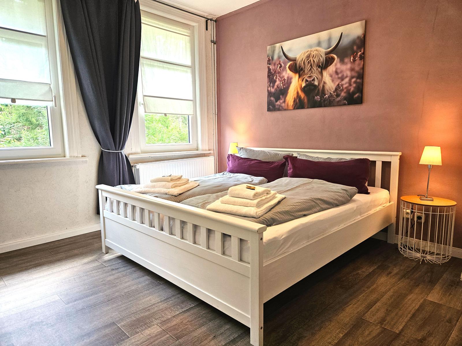 Schlafzimmer 1 von 5 mit Babybett sowie Kleiderschrank, Stummer Diener und Hocker.