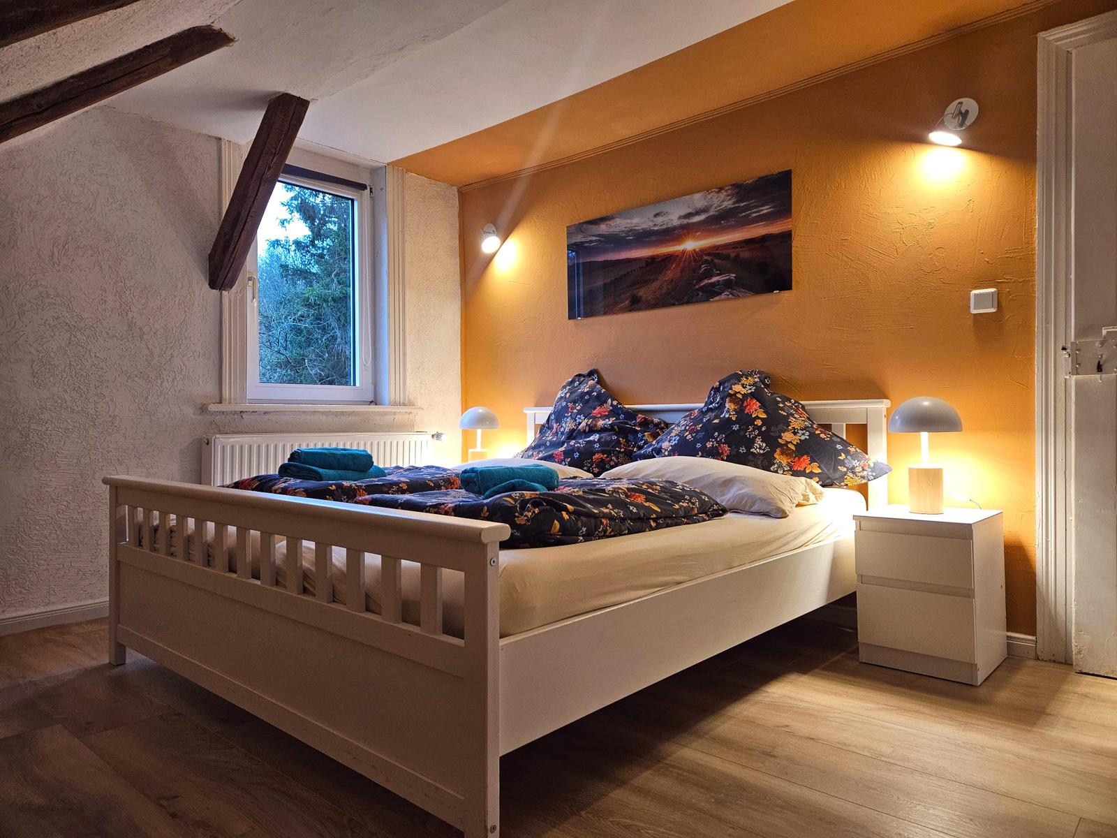 Schlafzimmer 4 von 5 mit einem Doppelbett und Komode sowie einem Kleiderständer.