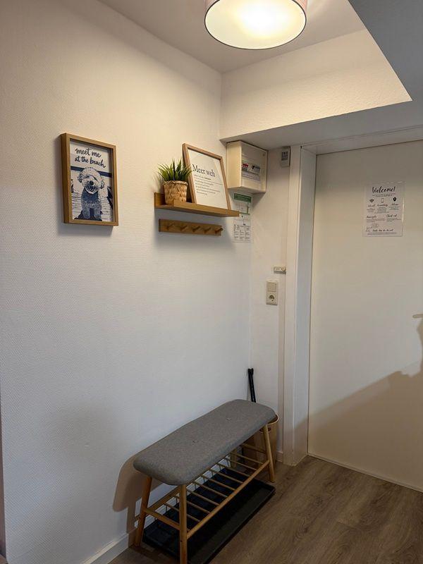 Entrance area with bench, wall shelf, and pictures on the wall.