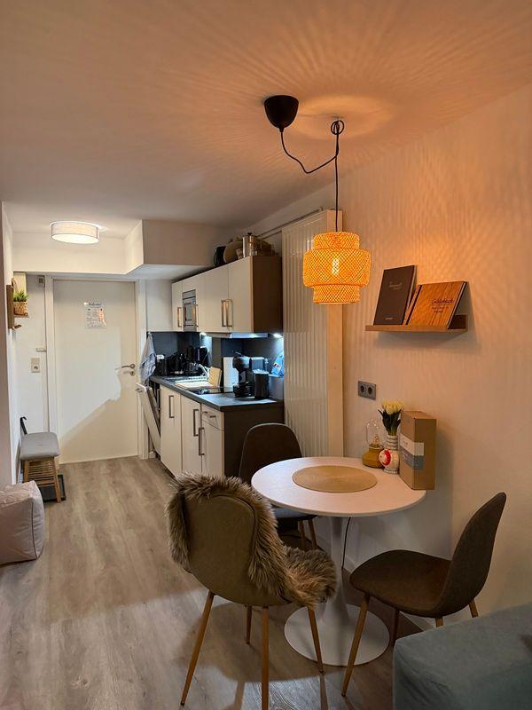 Kitchen with dining area and warm lighting on the wall.