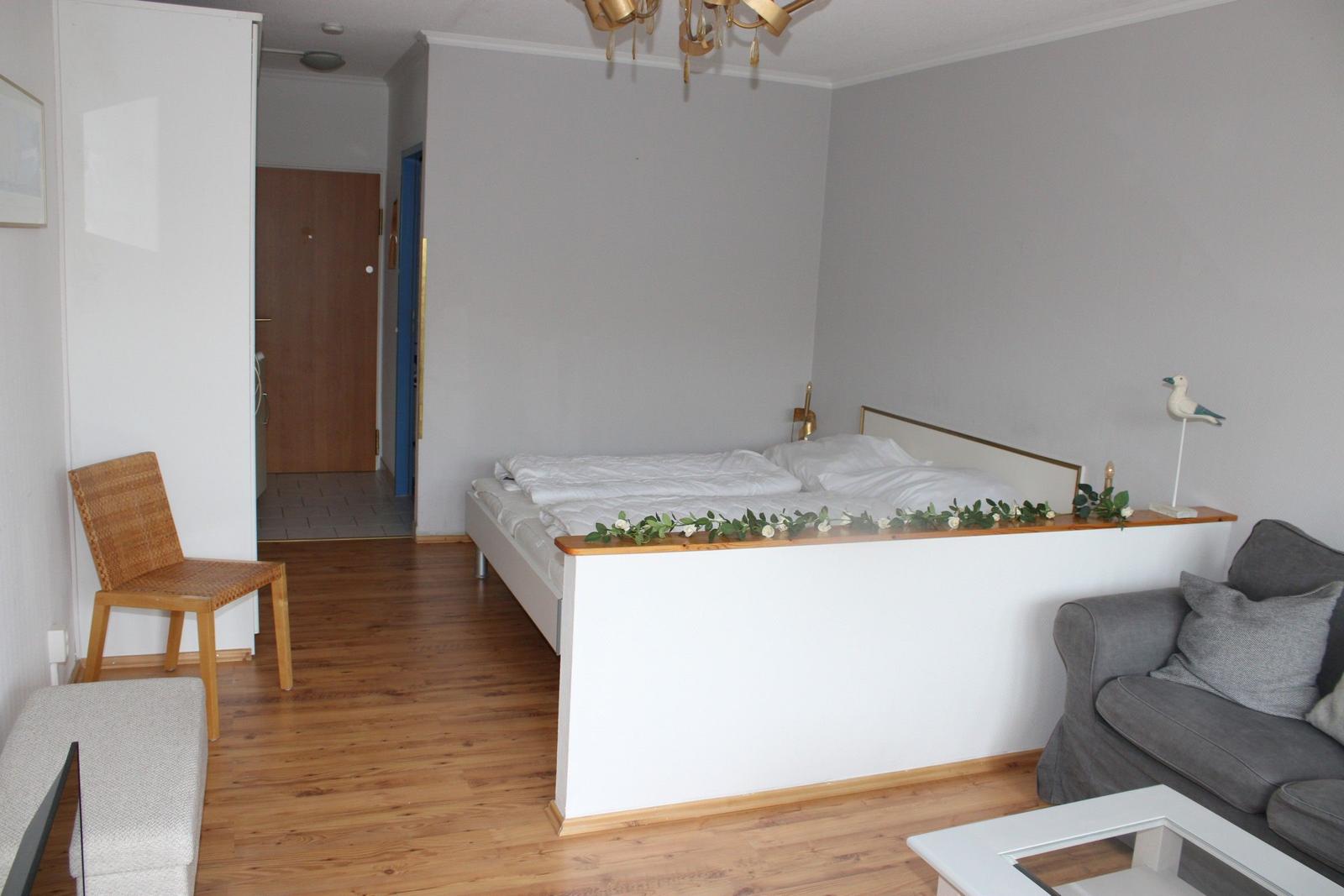 Schlafzimmer mit Bett, Sofa und Holzboden