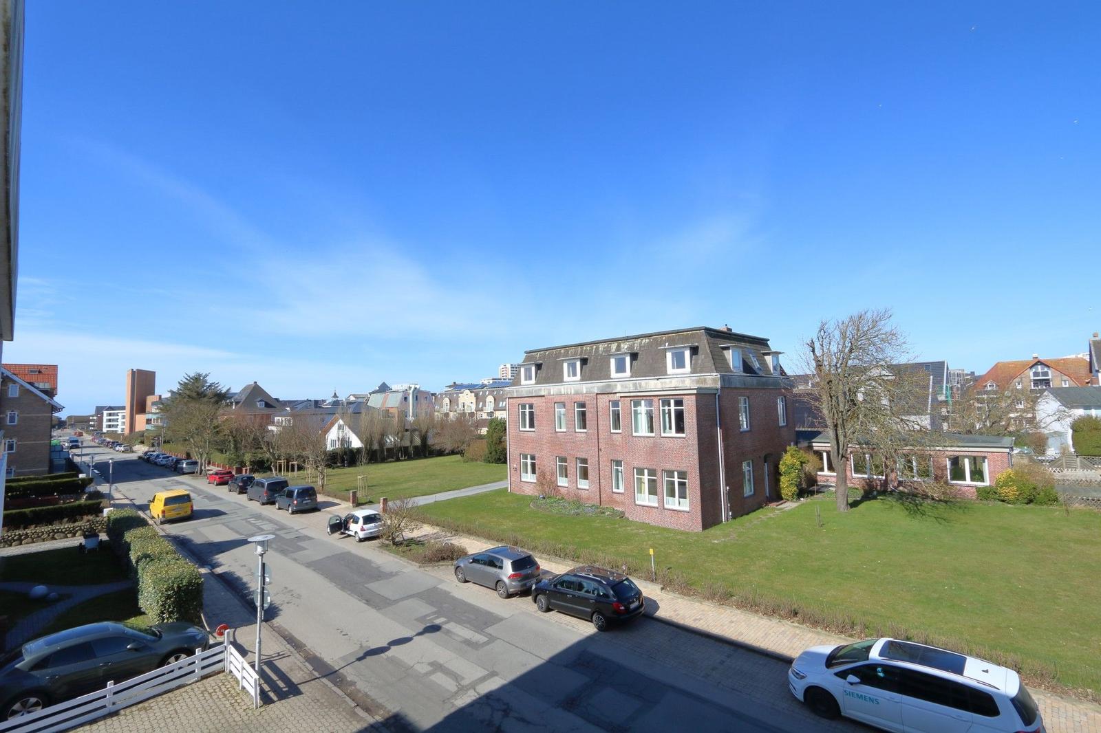 Rotes Backsteingebäude mit Dachfenstern und Grünfläche