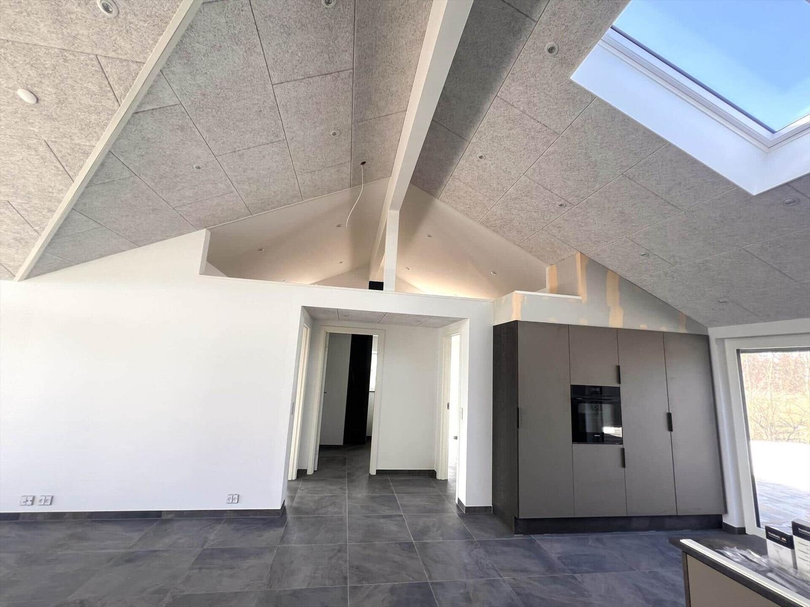 Moderne Küche mit integriertem Backofen und Dachfenster.