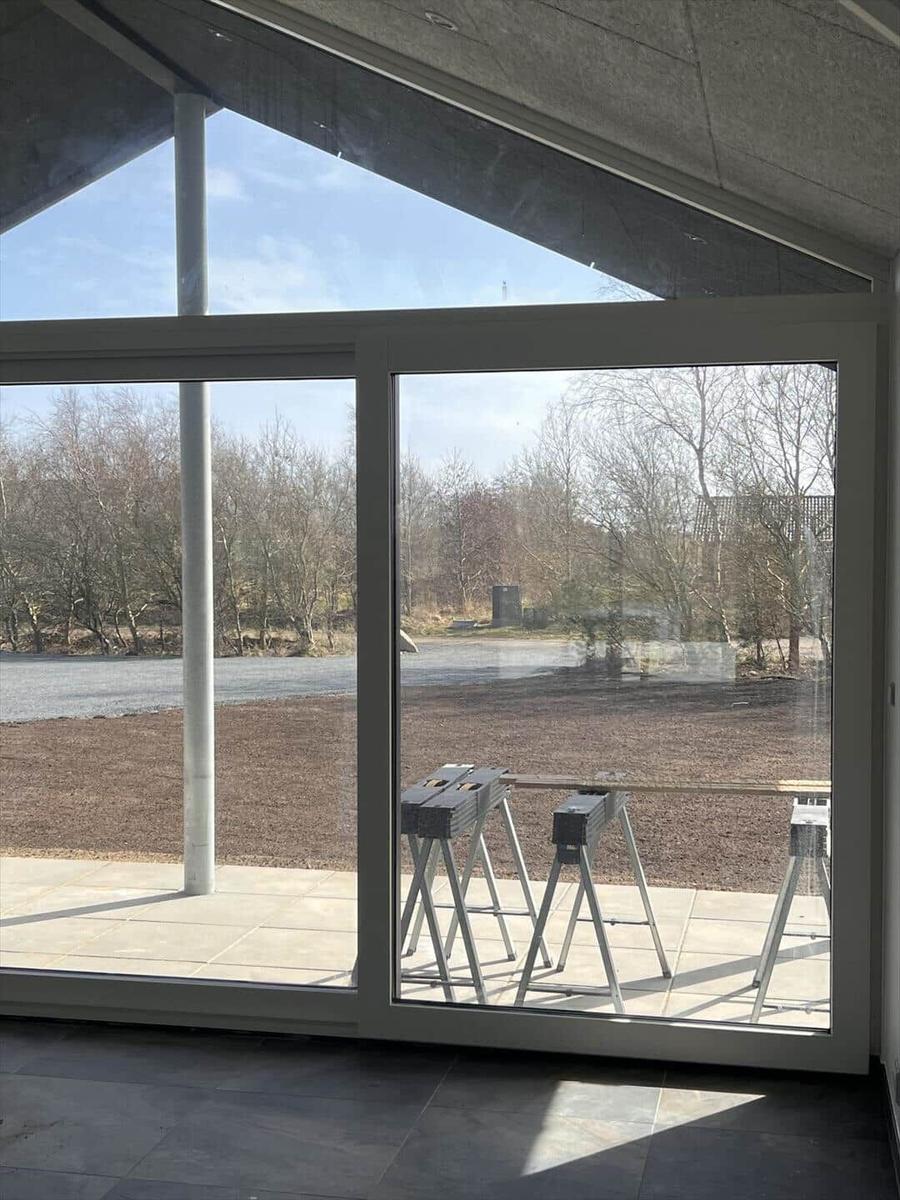 Große Glasfront mit Blick auf Außenbereich und Bäume
