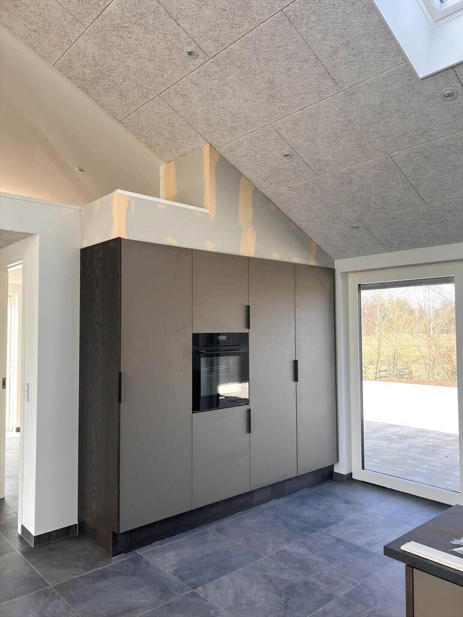 Moderne Küche mit integriertem Ofen und großen Fenstern.