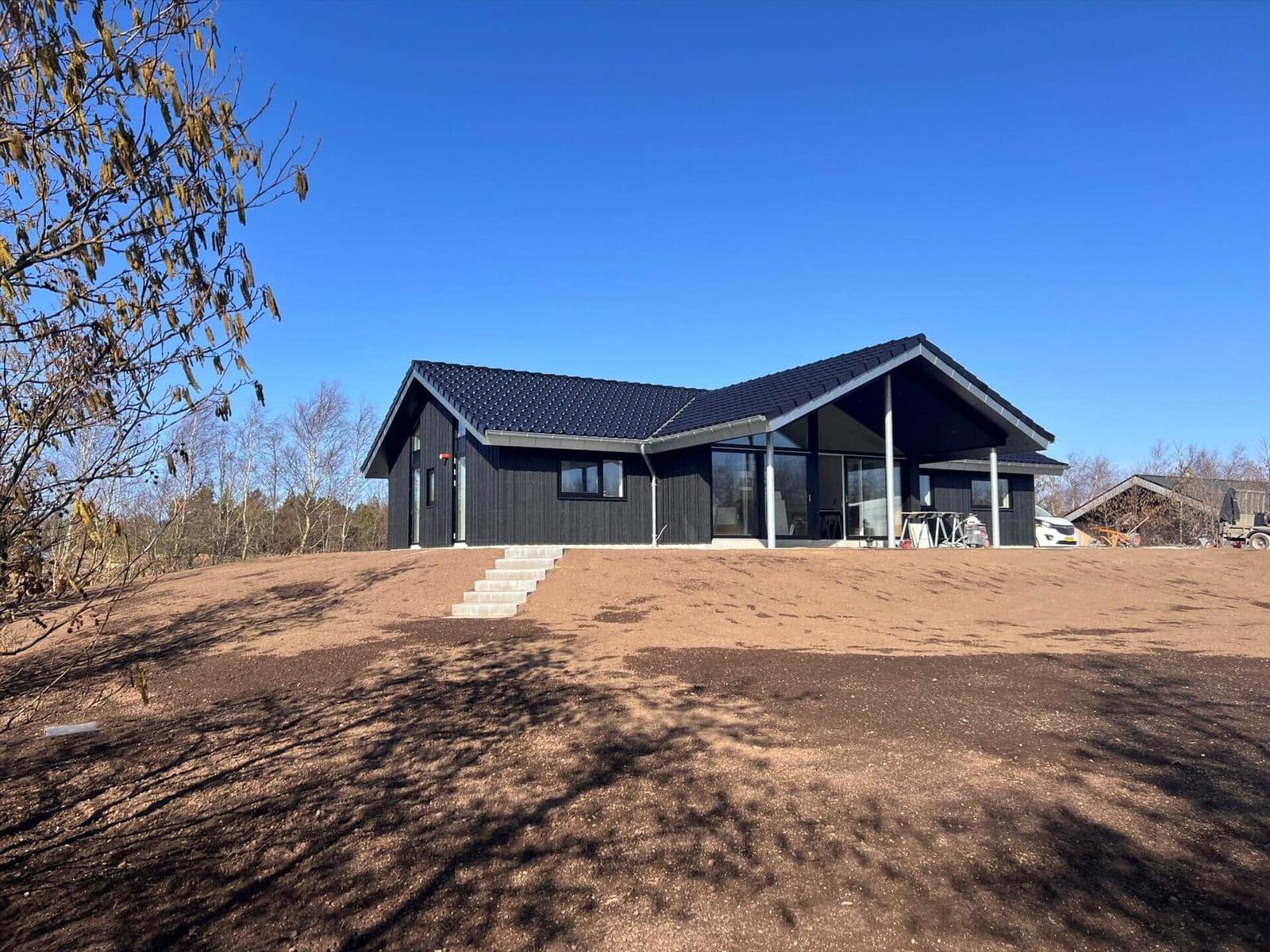 Moderne schwarze Villa mit großem Glasbereich und Terrasse