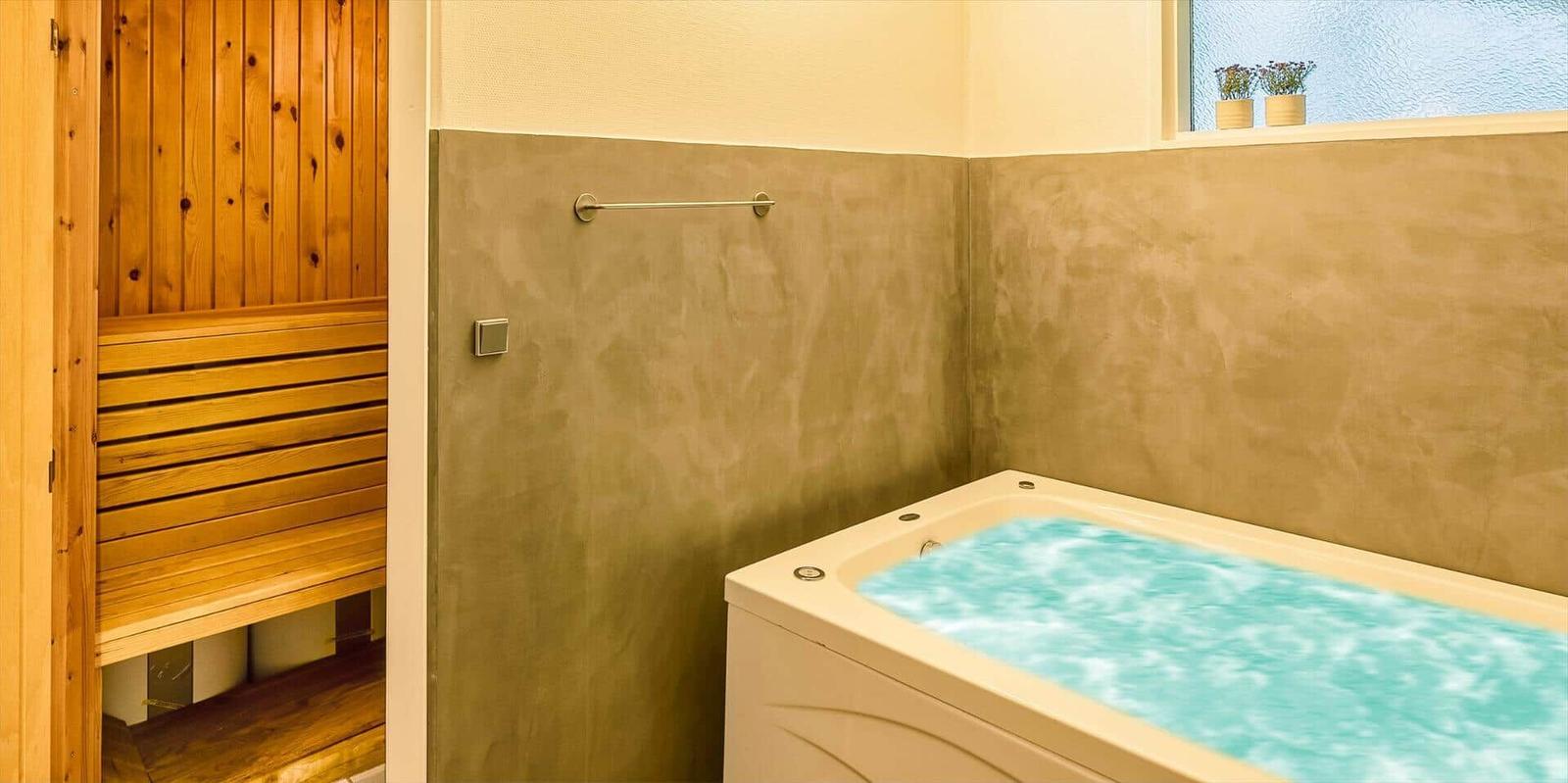 Bad mit Whirlpool und angrenzender Sauna.