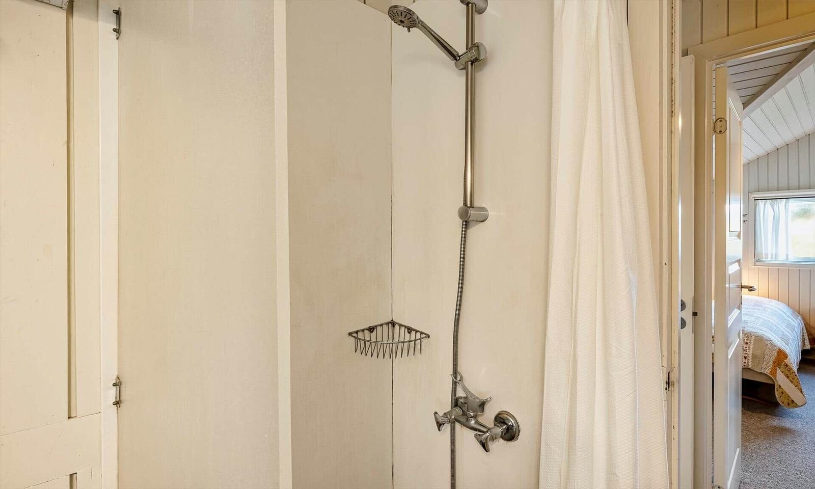 Dusche mit Duschbrause und Duschvorhang