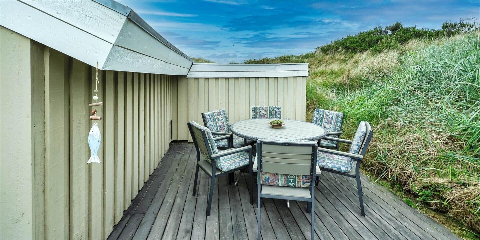 Terrasse mit runden Tisch und Stühlen neben Strandhütte